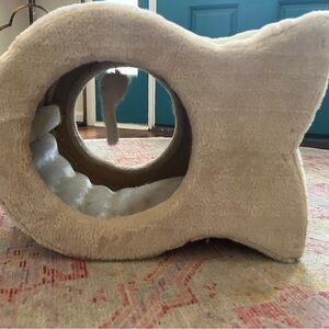 Cat hiding house if bed with scratch board and hanging mouse